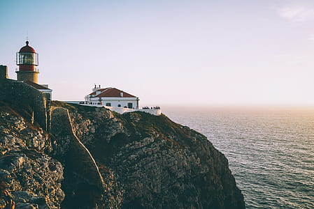 Lighthouse on Cliff Beside Body of Water thumbnail