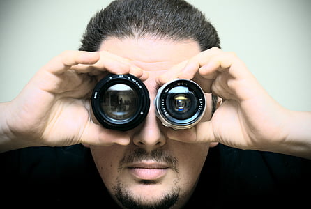 man wearing black shirts holding DSLR camera lens thumbnail