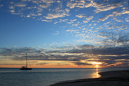 brown boat on sea under blue sky at daytime thumbnail