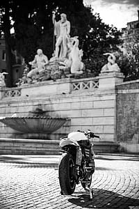 Grayscale Photography of Motorcycle Near Statues thumbnail