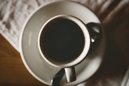white ceramic cup with black coffee on brown table thumbnail