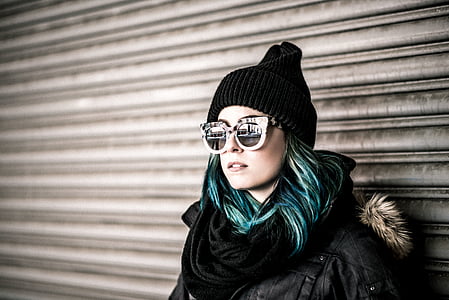 man wearing black coat, sunglasses and knit cap thumbnail
