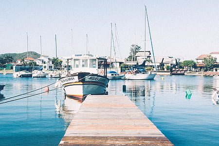 wooden dock beside yacht on body of water thumbnail
