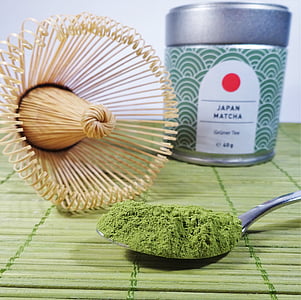 green powder in spoon near beige wisk thumbnail