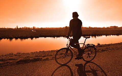man on biking along shore during golden time thumbnail