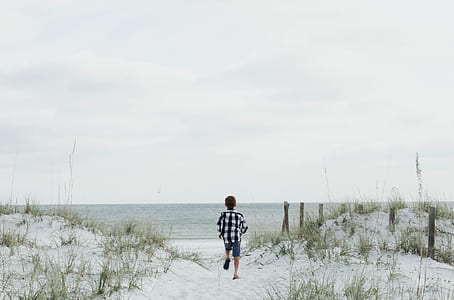 boy standing near body of water thumbnail