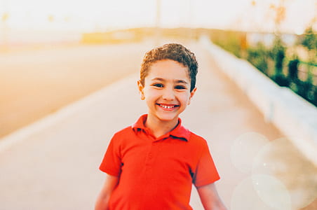 boy wearing red polo shirt standing near pavement thumbnail