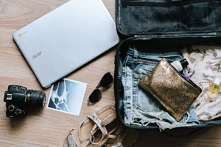 black DSLR camera beside gray Acer Chromebook and black luggage thumbnail