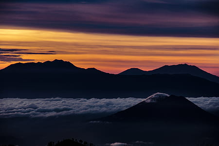 landscape photography of mountains under yellow sky thumbnail
