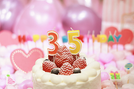 red and yellow 35-printed candle on cake with strawberries and blueberries thumbnail