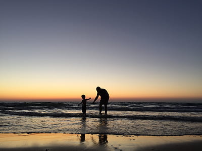 silhouette of man and toddler on seashore thumbnail