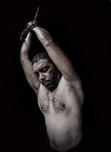 topless man tied using metal chain thumbnail