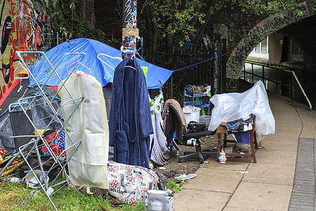 Tent and other domestic objects on canal bank in industrial area suggesting homelessness. thumbnail