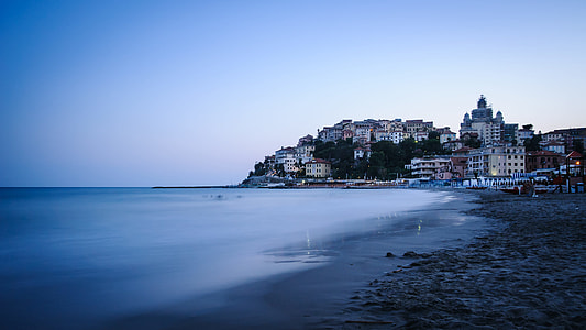 village on cliff near body of water thumbnail