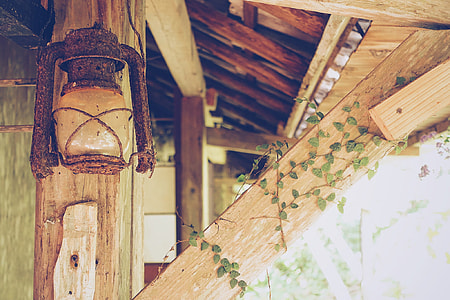 brown kerosene lamp hanging on wooden post thumbnail