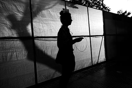 silhouette of woman standing near wall thumbnail
