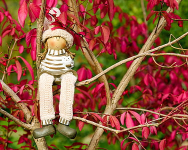 girl plush toy sitting on red leaf plant thumbnail