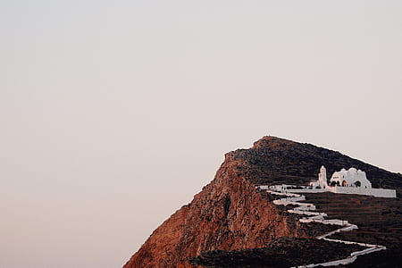 white concrete building on top of mountain under white sky during daytime thumbnail