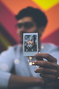 man holding his printed photo thumbnail