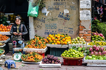 woman wearing black track jacket standing in front of weighing scale and fruit stand at daytime thumbnail