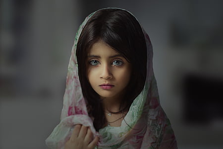 tilt shift lens photography of girl wearing pink hijab headdress thumbnail