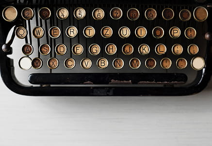 black typewriter on white wooden table thumbnail