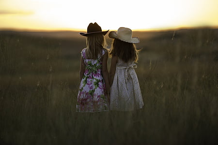two girl wearing hats watching sunrise during daytime thumbnail