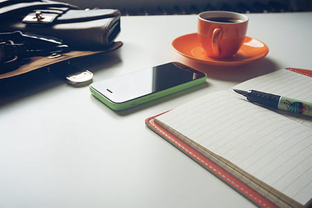 green iPhone 5c beside orange ceramic teacup and saucer thumbnail