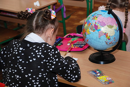 girl wiring paper leaning on brown table thumbnail