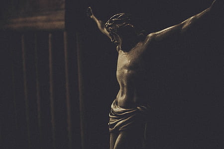 crucifix of Jesus Christ sculpture hanged on black painted wall thumbnail