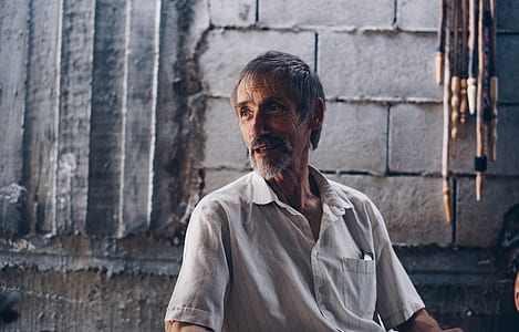 man wearing button-up polo shirt near gray concrete wall thumbnail