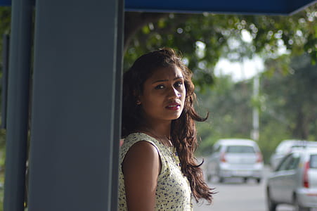 Photo of Woman in White Blouse Leaning on Gray Steel Shed thumbnail