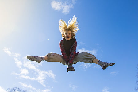 woman jumps under cloudy day thumbnail