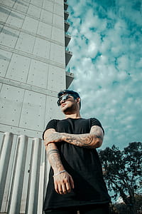 person standing beside gray high rise building thumbnail