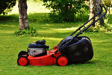 red and black push mower on grass field thumbnail