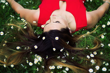 woman in red sleeveless top lying on green leaf plants thumbnail