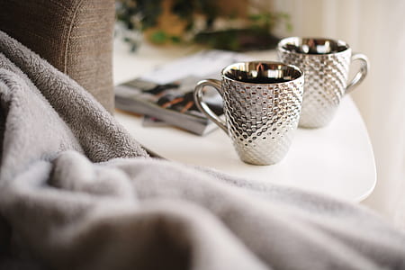 two white-and-silver mugs on table thumbnail