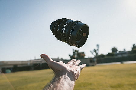 person catching a black DSLR camera lens thumbnail
