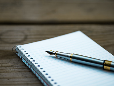gray fountain pen near spiral notebook thumbnail