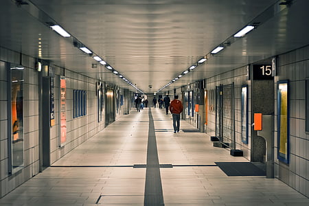 man in brown jacket walking on hallway thumbnail