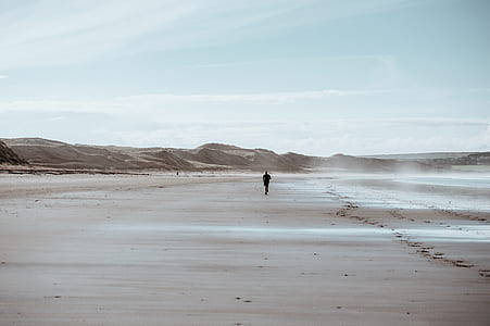 person walking in desert during daytime thumbnail