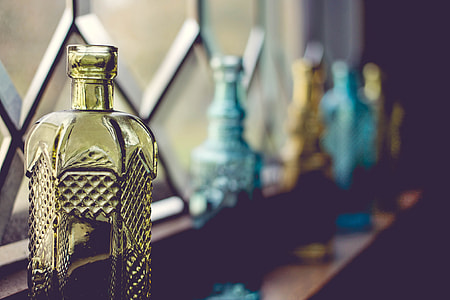five assorted-color glass bottles on brown surface thumbnail