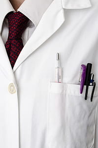 person wearing white top with three pens on front pocket thumbnail