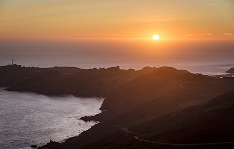 silhouette photo of mountain near body of water during sunset thumbnail
