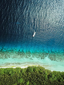 aerial photography of yacht near shore thumbnail