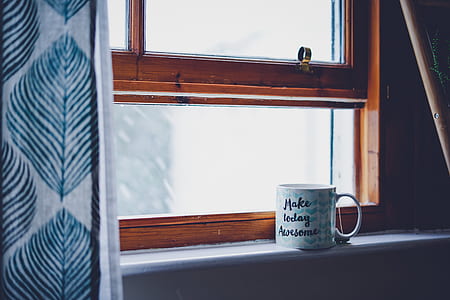 white and blue ceramic mug beside window thumbnail