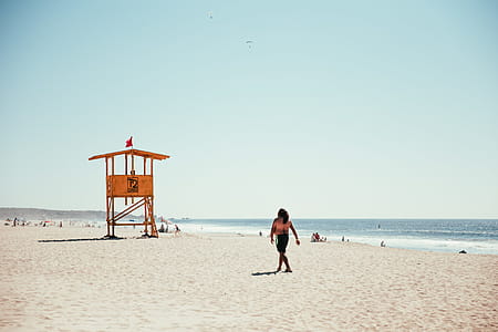 A lifeguard tower on the beach surrounded by sand and sea waves thumbnail