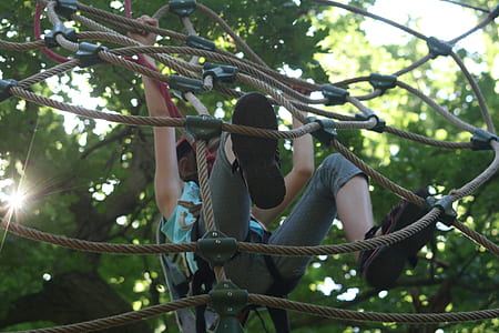 person hanging on brown rope at daytime thumbnail