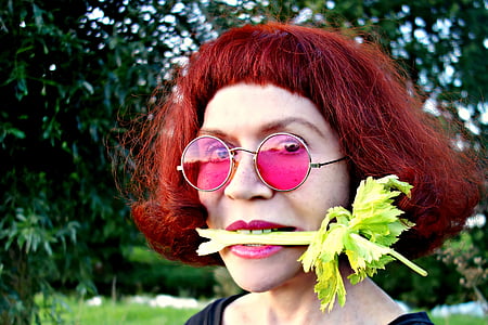closeup photo of person biting green vegetable food thumbnail