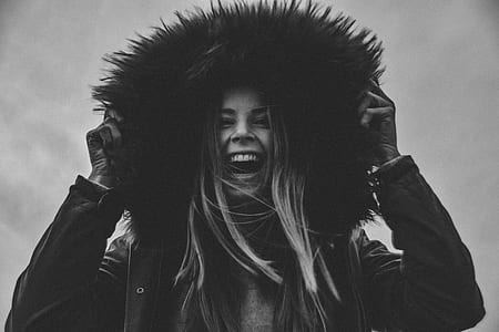 grayscale photo of woman holding fur on jacket thumbnail